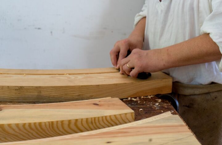 Ervaren ambachtelijke meubelmaker aan het werk met hout voor unieke meubels.